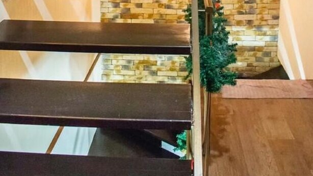 A staircase with a stone wall background and a metal handrail. - Hostel Koleso (Odesa)