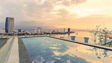 Una piscina al aire libre, sillones reclinables de piscina