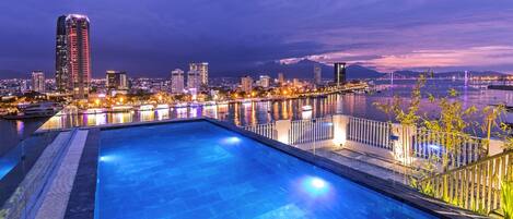 Une piscine avec vue sur la ville au crépuscule.