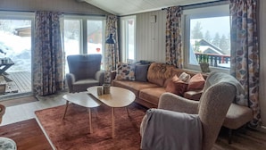 Un salon confortable avec un canapé, des fauteuils, une table basse et un tapis.