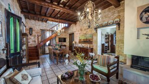 A rustic interior with a wooden staircase, a dining area, and a fireplace. - Villa Arhontariki stunning view, pool, BBQ close to Kissamos, Chania (KISSAMOS)