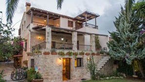 A two-story stone building with balconies, a staircase, and potted plants. - Villa Arhontariki stunning view, pool, BBQ close to Kissamos, Chania (KISSAMOS)