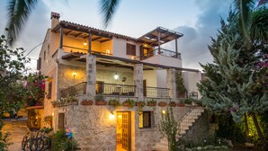 A two-story stone building with balconies, outdoor lighting, and potted plants. - Villa Arhontariki stunning view, pool, BBQ close to Kissamos, Chania (KISSAMOS)