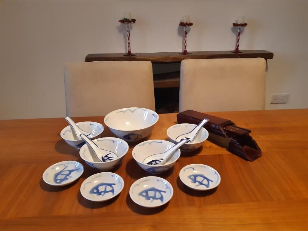 Ein Esstisch mit Schüsseln und Löffeln, eine Tafel Schokolade und eine Holzsideboard mit Kerzen.