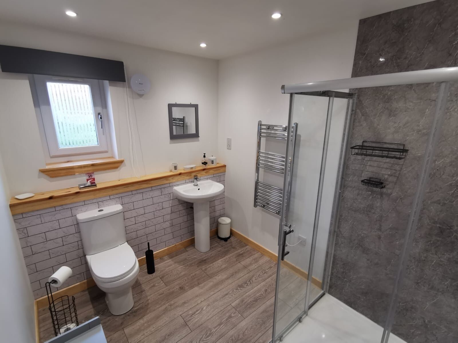 A modern bathroom with a toilet, sink, and shower.
