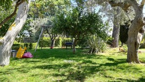 A park with a swing set, trees, and a dog. - B&B dal Barbarossa (Vasto)