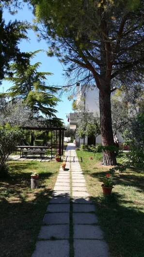 A garden pathway leading to a gazebo with outdoor seating. - B&B dal Barbarossa (Vasto)