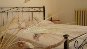 A bed with a metal frame, a bedside table with a lamp, and a radiator on the wall. - B&B dal Barbarossa (Vasto)