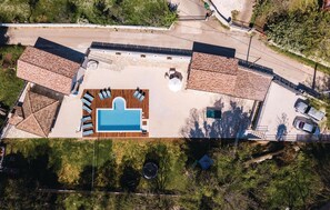 An aerial view of a property with a swimming pool, multiple roofed areas, and a parking lot. - Pet friendly home in Bibici with sauna (Bibici)
