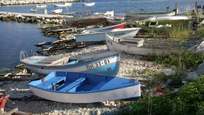A harbor with several boats docked along the shore, surrounded by rocky terrain and a distant pier. - Beautiful villa, stunning views, great location (Kranevo)