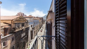 Un vicolo stretto con edifici su entrambi i lati, cielo sereno e una montagna sullo sfondo.