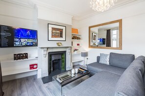 Appartement, 2 chambres | Salle de séjour | Télévisions à écran plasma