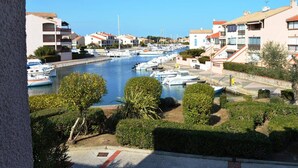 A marina with boats docked, surrounded by residential buildings with balconies and red-tiled roofs. - Saint-Cyprien Rental: 2-room apartment with parking, terraces, and loggia (Saint-Cyprien)