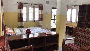 A room with a bed, a desk, a chair, and a bookshelf. - Happy Sedi Lodge (Pokhara)