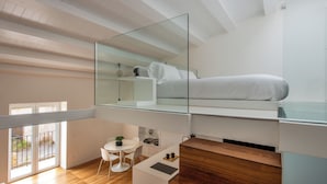 A modern loft bedroom with a glass ceiling, a bed, a small desk, and a balcony. - Kalsa miniLoft by Wonderful Italy (Palermo)