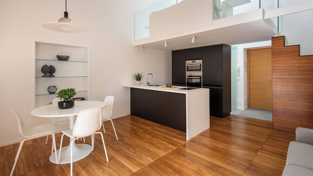 A modern kitchen with a central island, white chairs, and a dining table. - Kalsa miniLoft by Wonderful Italy (Palermo)