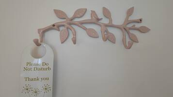 A wall-mounted branch decoration with a tag that reads "Please Do Not Disturb Thank you".