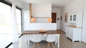 A modern kitchen with white cabinets, a wooden countertop, and two pendant lights. - cozy finca to relax and be active (Triquivijate)