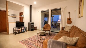 A living room with a sofa, a television, a fireplace, and a view through a glass door to the outside. - cozy finca to relax and be active (Triquivijate)