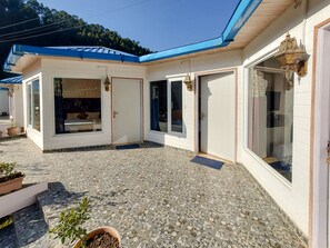 Un edificio con patio de baldosas, una puerta y una ventana.