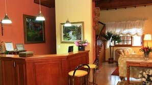 A cozy living room with a wooden bar, a sofa, and a dining area. - Pousada Sonnenhof (Gramado)