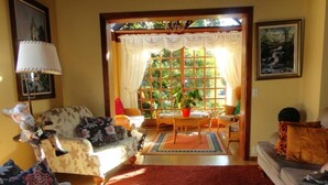 A cozy living room with a red carpet, a dining table with chairs, and a sofa. - Pousada Sonnenhof (Gramado)