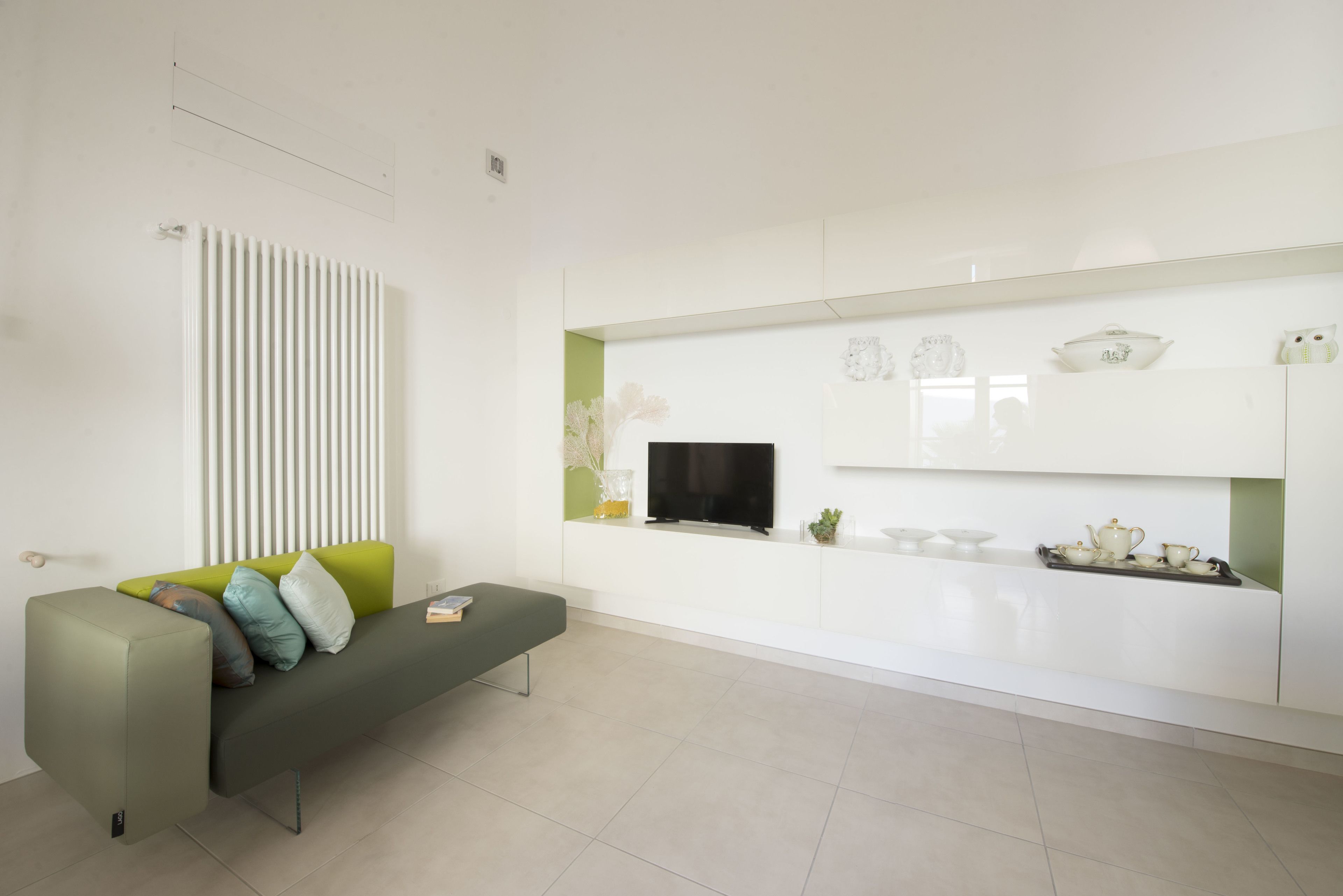 Ein modernes Wohnzimmer mit einer Couch, einem Flachbildfernseher und einem minimalistischen Design.