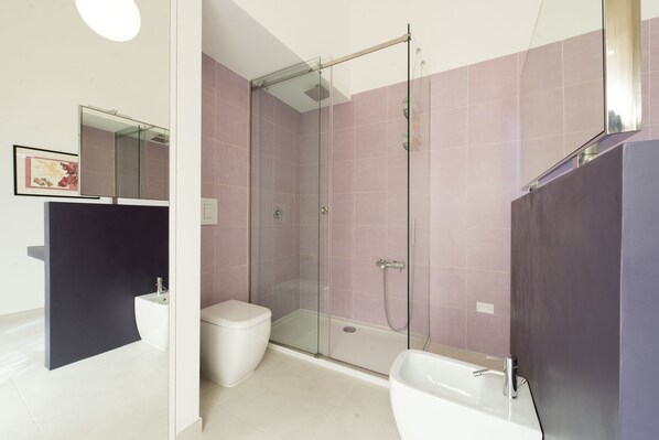 A modern bathroom with a glass-enclosed shower, a white toilet, and a white sink. - Gattopardo Apartments - LAGO Design by Wonderful Italy (Palermo)