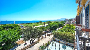 A balcony with a view of a coastal area, including a swimming pool and greenery. - Amazing Sea View in Historic Building in Downtown by Wonderful Italy (Palermo)