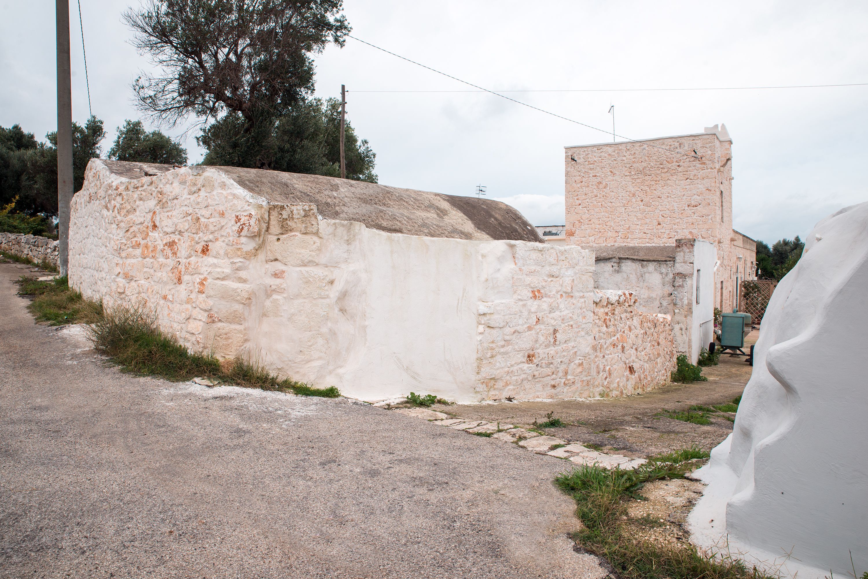 Un edificio in pietra con tetto piatto e una piccola struttura ad esso collegata.