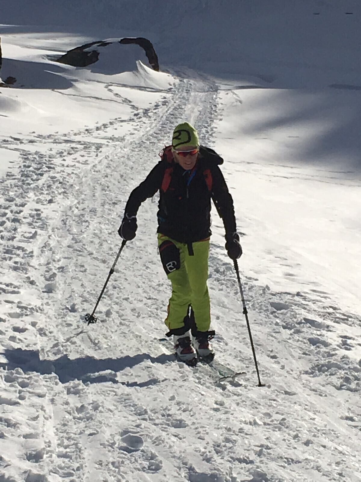 Une personne qui fait du ski sur une pente enneigée.