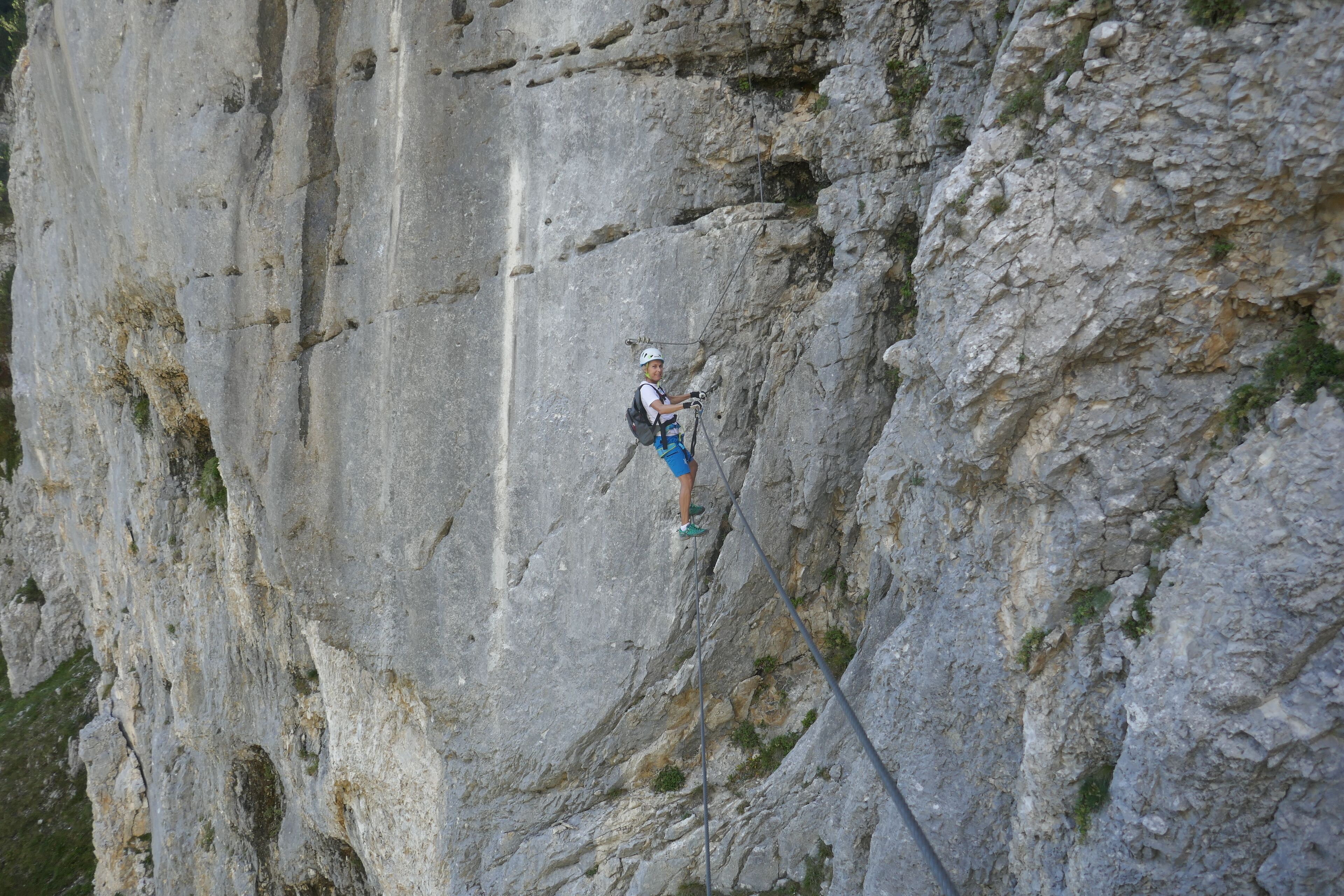 A person rappelling down a steep rock face.