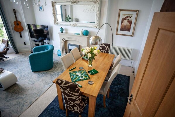 A dining area with a wooden table, chairs, and a chessboard. - Sea View Ultimate Boutique Escape! (Ilfracombe)