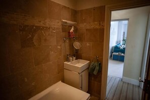 A bathroom with a bathtub, sink, and mirror. - Sea View Ultimate Boutique Escape! (Ilfracombe)