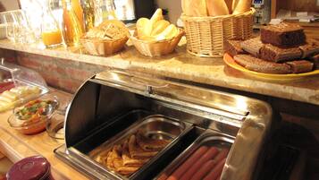 A buffet with hot dogs, bread, and various condiments.