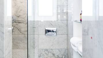 Un baño moderno con cabina de ducha de vidrio, inodoro y bidé.