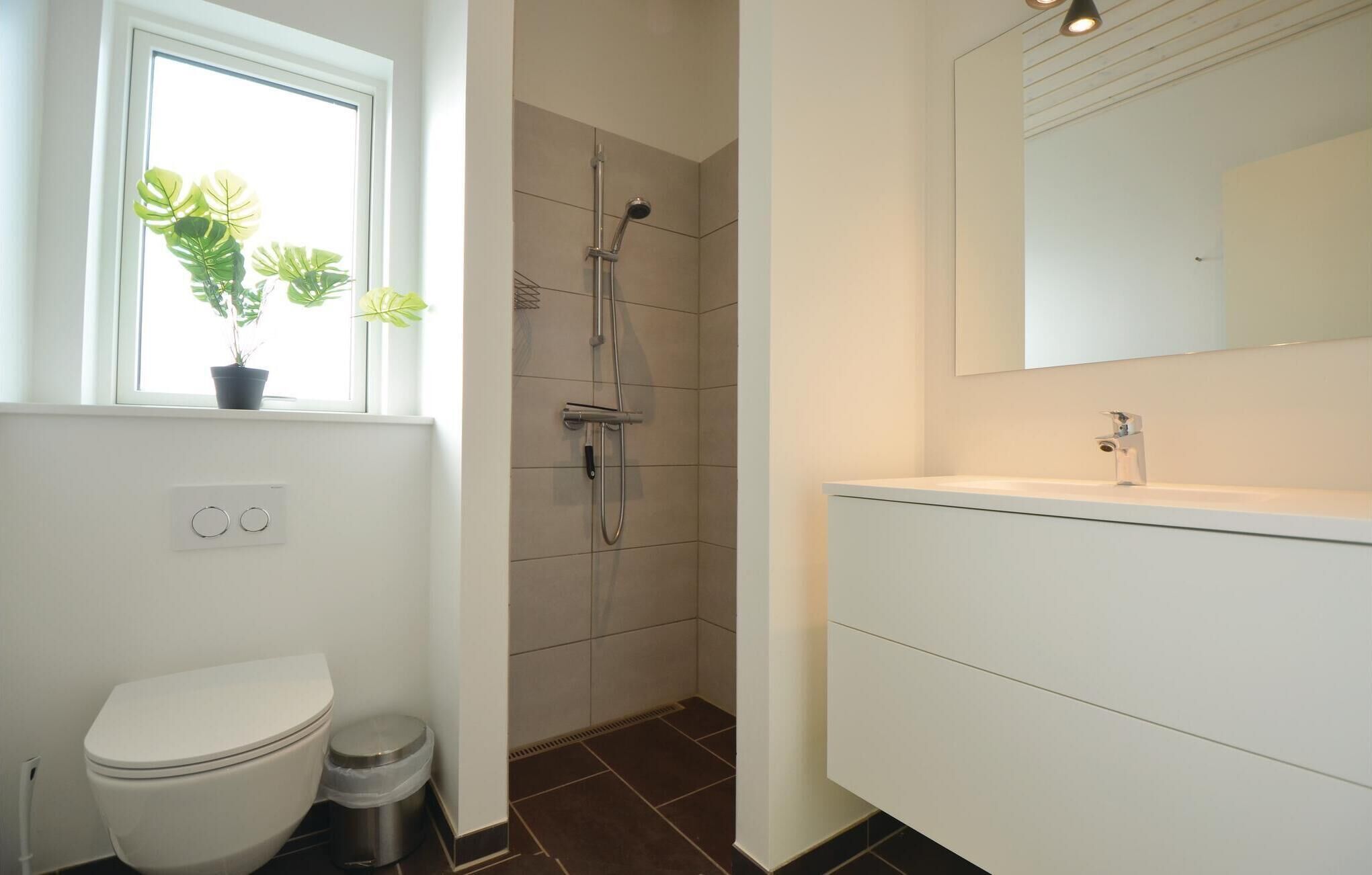 Ein modernes Badezimmer mit Toilette, Bidet, Dusche und Waschbecken.