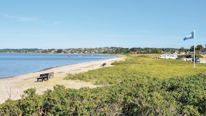 A beach with a bench, a flag, and a row of houses in the background. - Gorgeous home in Ebeltoft with WiFi (Ebeltoft)