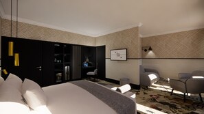 Une chambre d’hôtel moderne équipée d’un grand lit, d’une armoire, d’un bureau et d’un coin salon avec des fauteuils.