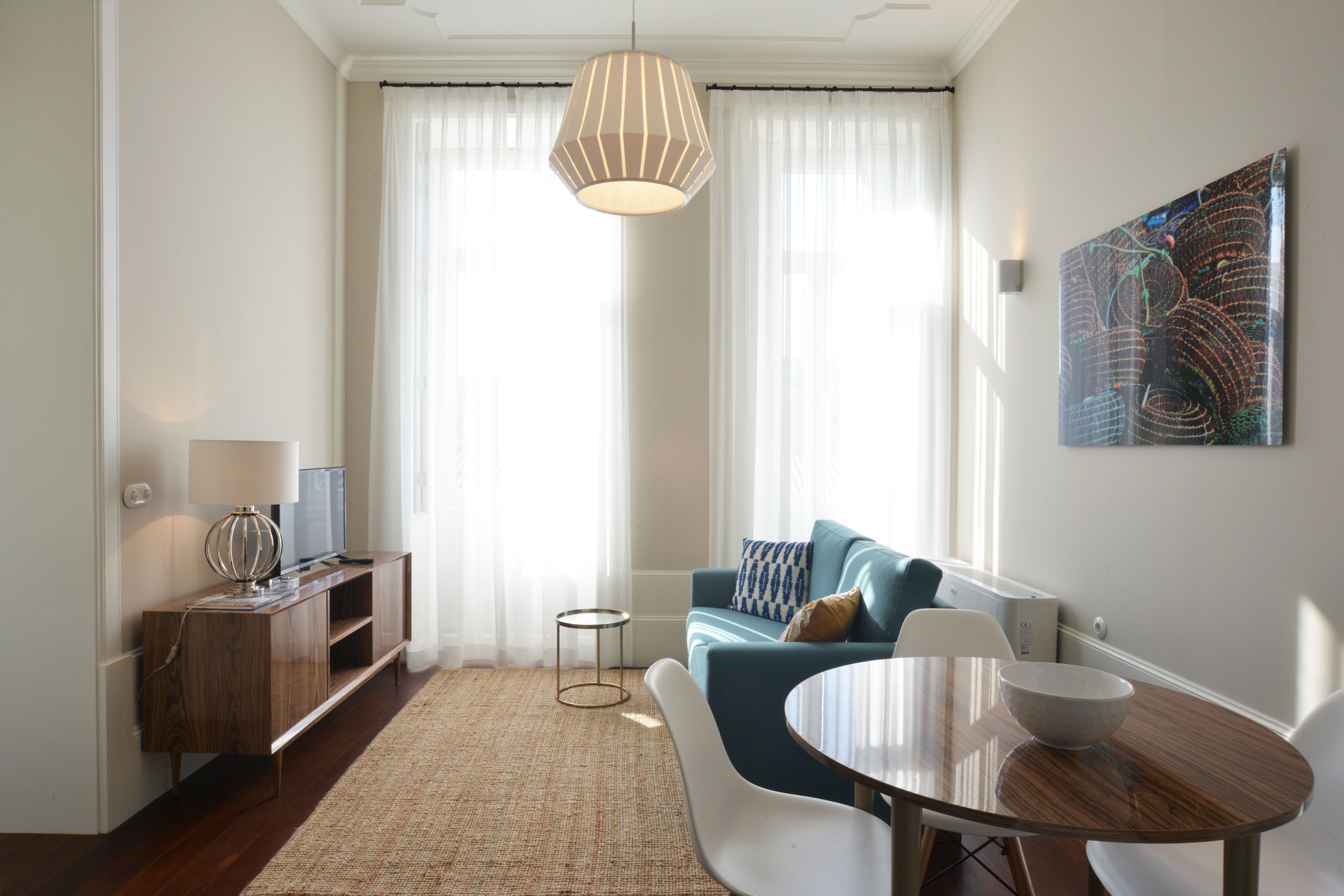 A modern living room with a sofa, a dining table, and a TV.