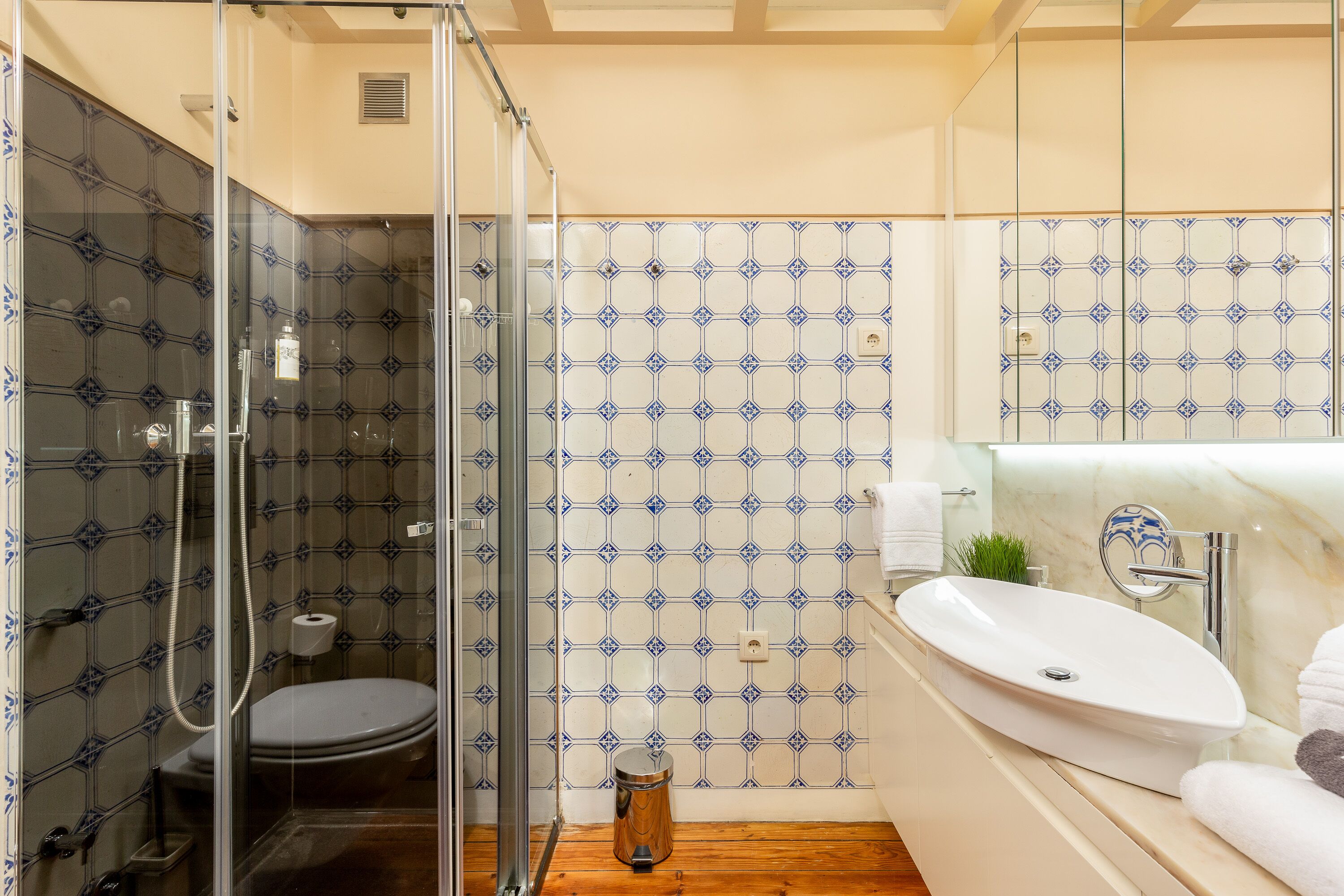 Une salle de bain avec une douche à parois de verre, des toilettes, un lavabo et un miroir.