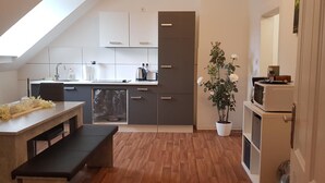 Une cuisine moderne dotée d’une lucarne, d’un coin repas avec un banc et d’une plante en pot.