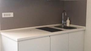 Eine kleine Küche mit Einbau-Mikrowelle, Spüle und Schränken.