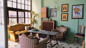 Une pièce comprenant un canapé, des fauteuils, une table et une carte accrochée au mur.