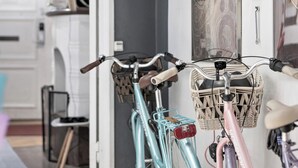 Bicicletas colgadas en una pared, una puerta con letrero de salida y un cuadro enmarcado.