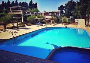 A swimming pool with lounge chairs and a small waterfall feature.