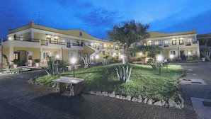 A hotel with a central courtyard, multiple balconies, and a well-lit entrance. - Villaggio Turistico Le Meridiane (Montenero di Bisaccia)