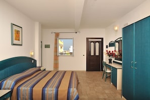 Un dormitorio con cama, escritorio y armario.