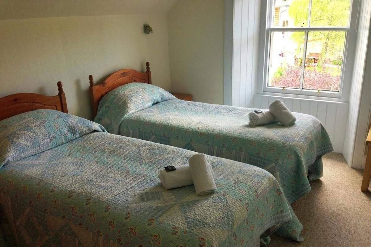 A bedroom with two beds, each with a patterned bedspread and pillows.