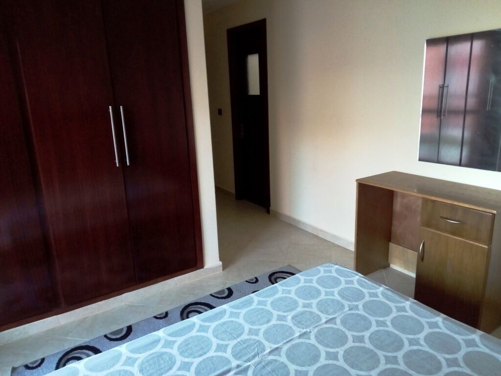 Une chambre à coucher avec un lit, une armoire et une commode.